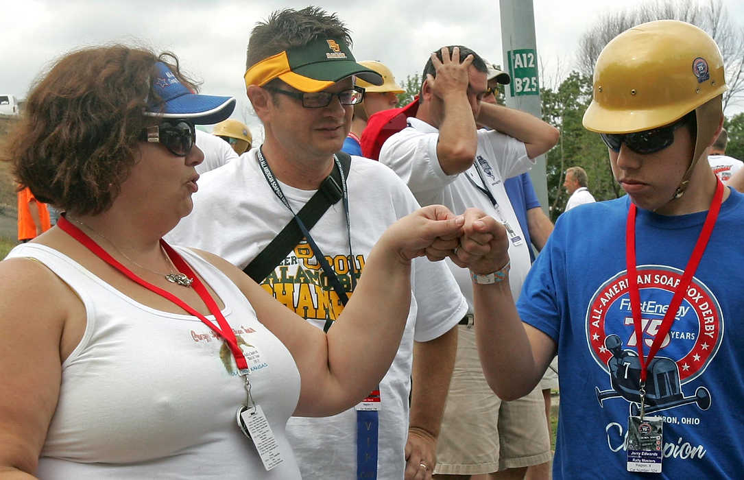 First place, Sports Picture Story - Ed Suba, Jr. / Akron Beacon JournalJerry Edwards of Olathe, Kansas (right) gets a fist bump from his mother and car handler, Debbie, before his heat in the Rally Masters division during the 75th annual FirstEnergy All-American Soap Box Derby at Derby Downs.