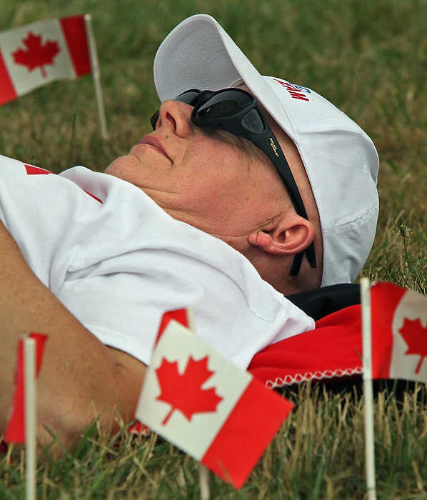 First place, Sports Picture Story - Ed Suba, Jr. / Akron Beacon JournalChris Murdock from Saint John, New Brunswick, Canada, takes a nap while waiting for his son, Drew, to compete in his heat of the Stock division during the 75th annual FirstEnergy All-American Soap Box Derby at Derby Downs.
