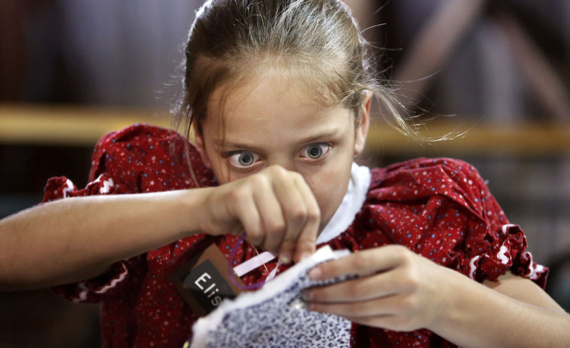 Second Place, Feature - Fred Squillante / The Columbus DispatchNine-year-old Elise Hedrick concentrates on a stitch as she learns about making quilts during Pioneer Day at Heritage Park in Westerville. 