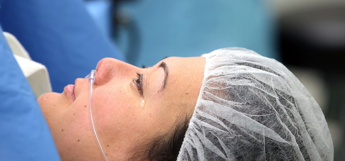 First Place, Feature Picture Story - Chris Russell / The Columbus Dispatch Birth mother Annie Johnston sheds a single tear as she lies on an operating table at Riverside Hospital following the successful birth of her twin girls by cesarian section on October 24, 2013.  