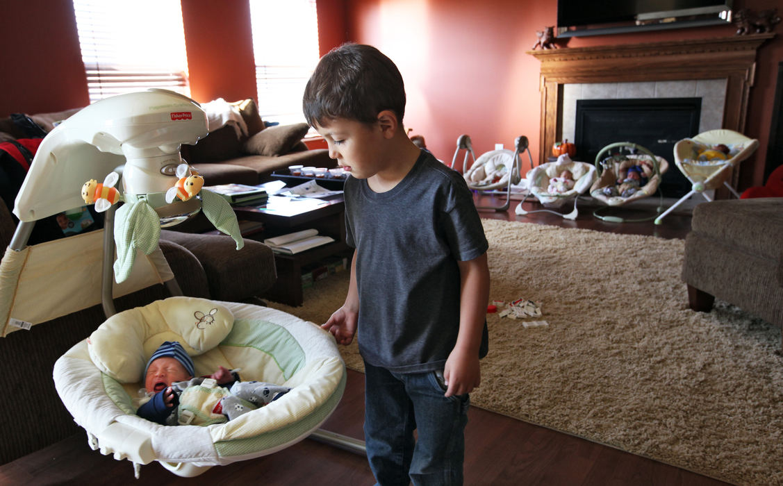 First Place, Feature Picture Story - Chris Russell / The Columbus Dispatch Chrissy's oldest son, Wendell Knott helps rock one of his newborn cousins to sleep after their arrival at the Johnston home.