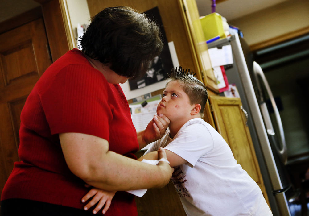Second Place, Feature Picture Story - Eric Albrecht / The Columbus DispatchMurphy Vetter 11 a special needs child gets a stern reminder of the rules he must follow after acting aggressive toward his mom Tina Vetter at their home .Despite Murphy's autism and Down syndrome he engages in a normal school and is the first child to participate in the Olentangy Youth Football Association  because his parents believe keeping him in the mainstream helps Murphy from becoming institutionalized.