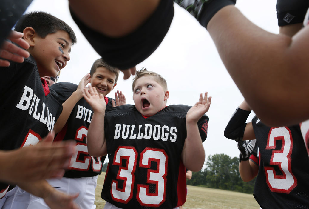 Second Place, Feature Picture Story - Eric Albrecht / The Columbus Dispatch.In one of his favorite activities Murphy Vetter 11 leads his team the Bulldogs in pregame cheers and huddles .