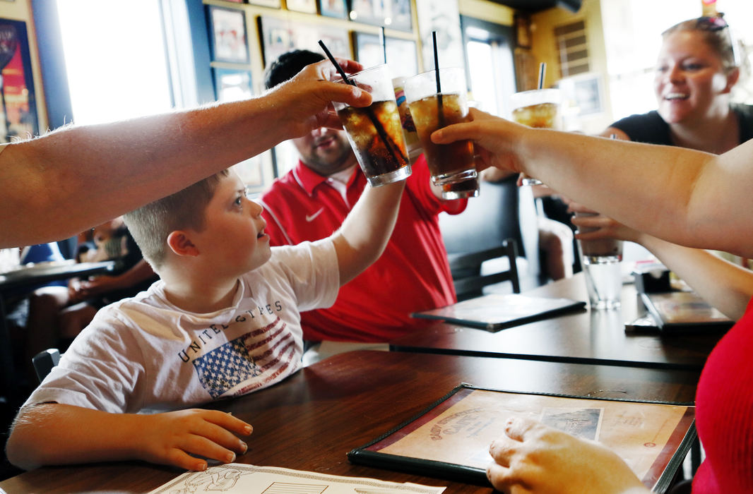 Second Place, Feature Picture Story - Eric Albrecht / The Columbus DispatchMurphy Vetter 11 instigates a toast with family and friends at Easy Street Cafe in Powell on a family outing .