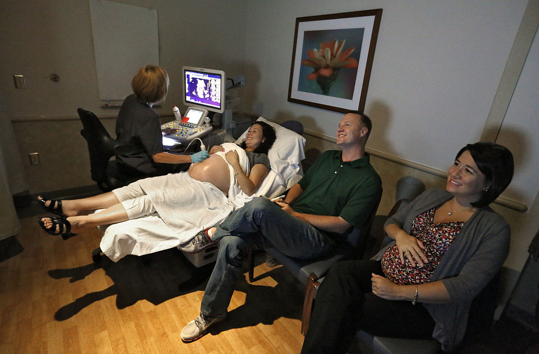 First Place, Feature Picture Story - Chris Russell / The Columbus Dispatch Annie Johnston undergoes an ultrasound to monitor her babies health at Riverside Hospital's Women's Health Center while her husband Joby and pregnant sister Chrissy Knott watch the results on a wall monitor.  