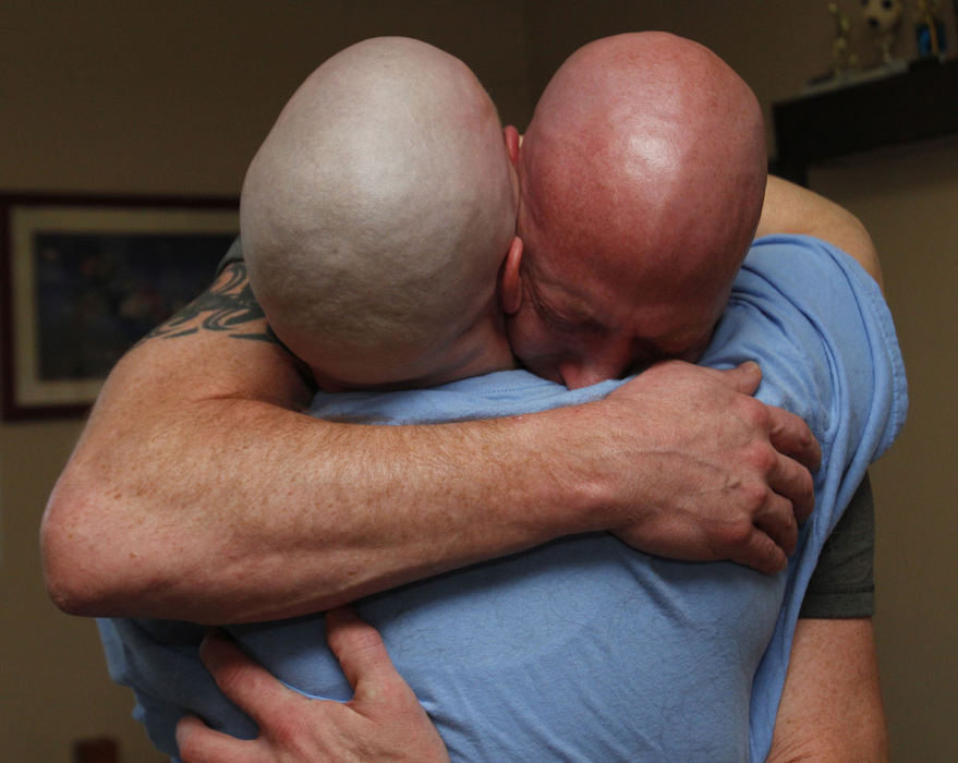 Award of Excellence, Feature Picture Story - Karen Schiely / Akron Beacon JournalMichelle Lang-Schock (left) comforts her brother Adam Lang as he cries after her head was shaved because of her hair loss from chemotherapy. Several family members and friends participated in the day as a show of support for Michelle. 