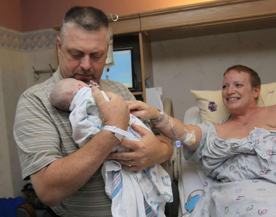 Award of Excellence, Feature Picture Story - Karen Schiely / Akron Beacon JournalMichelle Lang-Schock smiles as her husband Harry  holds their daughter Charli for the first time after her birth at the Akron General Medical Center.