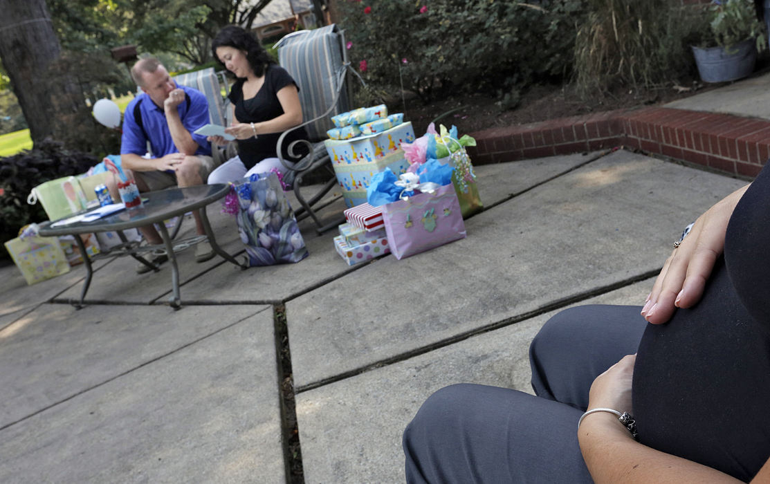 First Place, Feature Picture Story - Chris Russell / The Columbus Dispatch Annie Johnston and her husband Joby open baby shower gifts while Annie's sister Chrissy Knott, who was serving as their surrogate mother  looks on.   Chrissy was pregnant with their twin boys. 