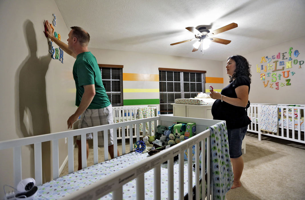 First Place, Feature Picture Story - Chris Russell / The Columbus Dispatch Annie and Joby Johnston work to decorate the wall of the quads nursery at their home in Delaware about a month prior to delivery.  