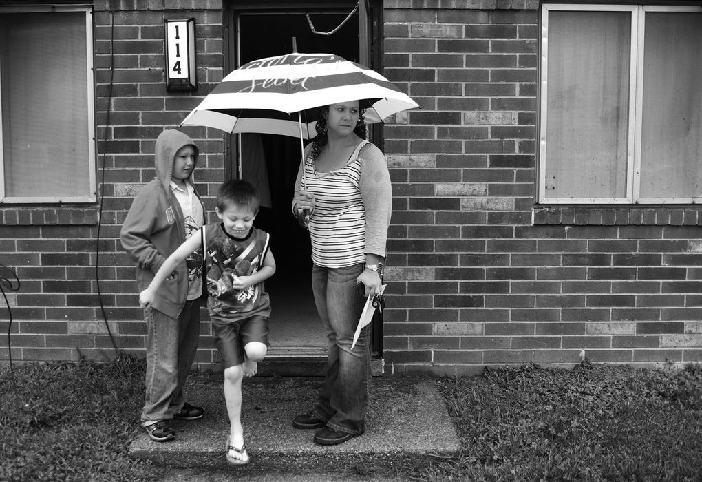 Award of Excellence, Feature Picture Story - Kristin Bauer / The (Elyria) Chronicle-TelegramTabitha Crabtree and her sons Scott, 10, and Dillon, 6, stand outside their Wilkes Villa home preparing to move on Saturday, July 27.  Tabitha speaks with her eldest son Scott about packing the truck to make the move as her youngest son Dillon hops around on one foot after losing a flipflop. This will be the family's first home, as Tabitha prepares to leave the safety net of Wilkes Villa for becoming a first-time homeowner.
