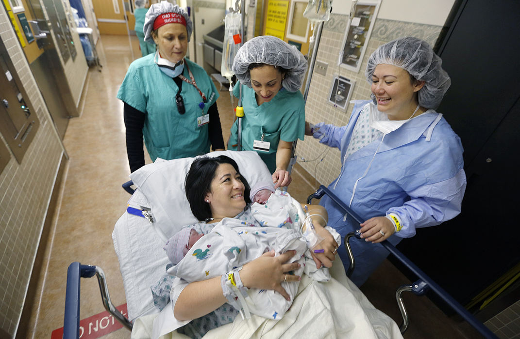 First Place, Feature Picture Story - Chris Russell / The Columbus Dispatch Dr. Jaina Lindauer and nurse anesthetist Diana Sipes look on as the sisters share a moment as surrogate mother Chrissy Knott holds the two boys she gave birth to for her sister Annie Johnston.