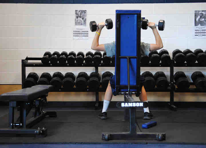 First Place, Larry Fullerton Photojournalism Scholarship - Jenna Watson / Kent State UniversityKent State's first female football kicker April Goss participates in an optional team weight lift session Nov. 9, 2012. Goss stays involved in team activities even during away games that invite only starting players along. 