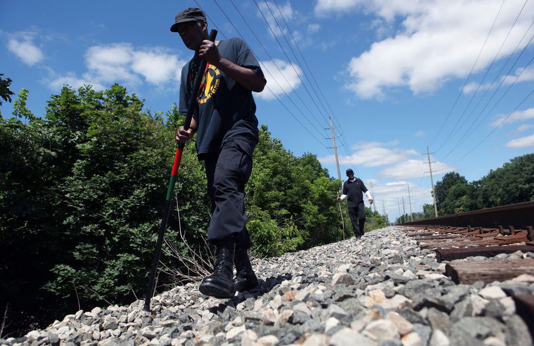 Award of Excellence, News Picture Story - Gus Chan / The Plain DealerVolunteers search railroad tracks behind the East Cleveland Civic Center looking for more bodies of missing women.  The search continued for bodies after the discovery of three bodies wrapped in plastic bags last weekend. 