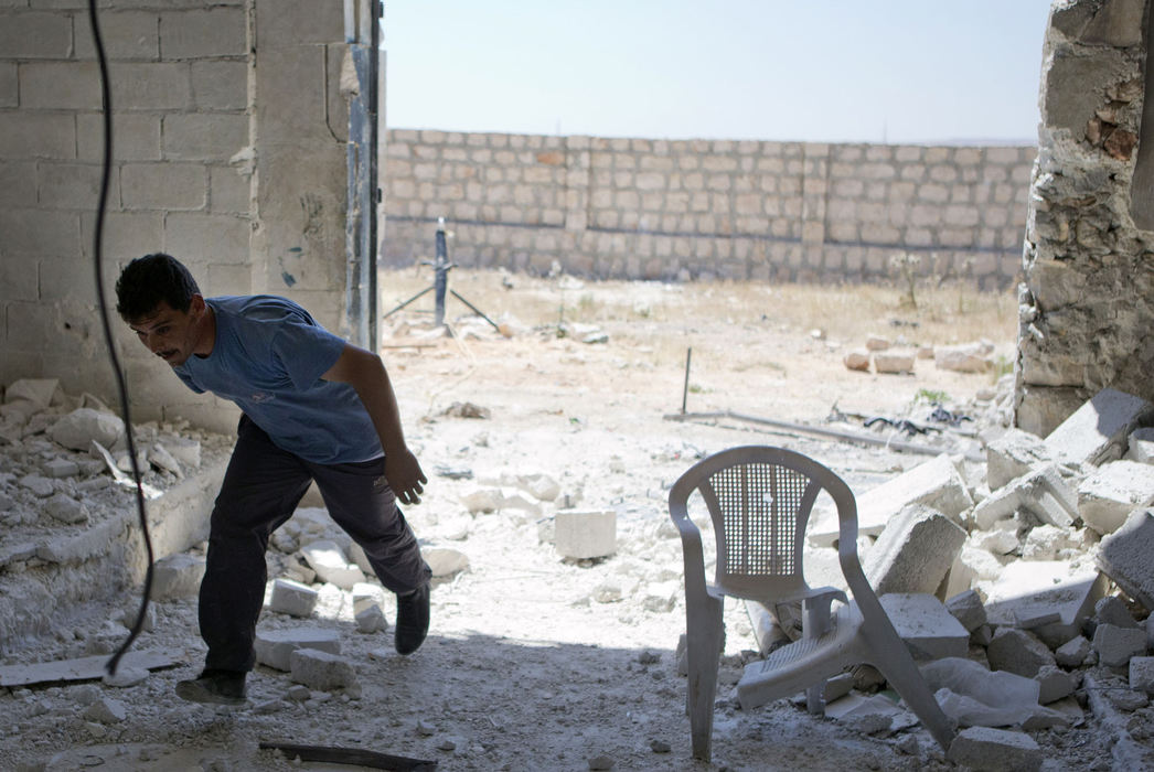 Award of Excellence, News Picture Story - Coty Giannelli / Kent State UniversityA Free Syrian Army fighter, formerly an officer in the Syrian Army, takes cover as he prepares to fire a Syrian-made mortar at a regime-held position in northern Syria on June 22, 2013. 