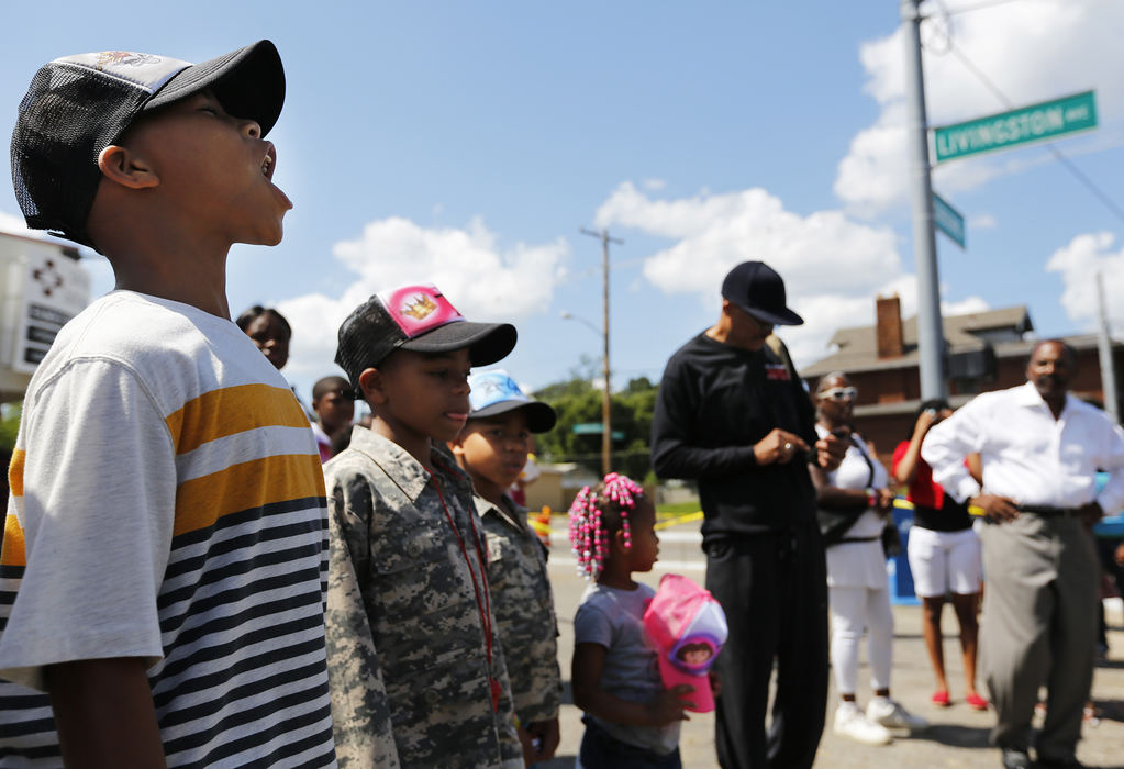 Second Place, James R. Gordon Ohio Undertanding Award - Eamon Queeney / The Columbus DispatchFrom left: Trevon Dowling, 9, calls out a military-style chant against violence as he stands with his siblings Gerald, 8, Jeremiah, 7, Jaliyah, 3, while their mom Tanisha, of the East Side, watches during the 46th South Side March, Sunday afternoon, August 4, 2013. On the first Sunday of every month the community around the Family Missionary Baptist Church on the South Side stages a march against violence. An 42-block area on the South Side plagued with shootings and nicknamed Soufganistan by the youth there went almost 2 years with no deaths until this summer. 