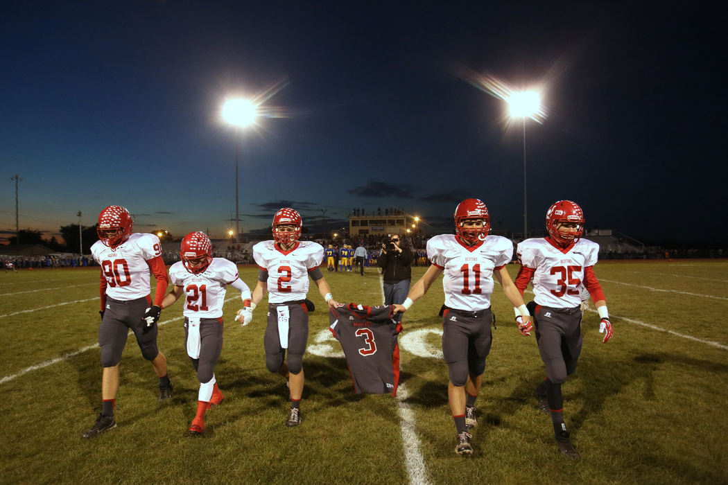 First Place, Photographer of the Year - Large Market - Katie Rausch / The (Toledo) BladeBedford's senior Jeremy Harris (90) Lucas Mayo (21) Boss Brad (2) Alec Hullibarger (11) and Jack Maison (35) carry their teammate Colton Durbin's number three jersey off the field before the start of the Friday, Oct. 25, 2013, match up between Monroe Jefferson and Bedford. Bedford senior Colton Durbin was taken off life support Thursday after being injured in a car accident Wednesday. In addition to a moment of silence held before the beginning of the game, Colton's family and friends wore buttons, face painting and held his number aloft in his honor. 