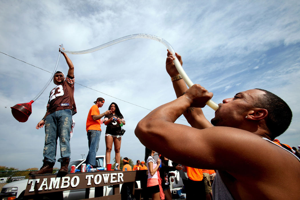 Second Place, Photographer of the Year - Large Market -  Lisa DeJong / The Plain DealerWho needs coffee for breakfast when there is a beer bong? Jamey Farren, 27, of Painesville, far left, stands on the Tambo Tower as he helps the beer flow through the beer bong to Carlos Bellinger, 26, of Painesville, far right, at the infamous Muni Lot near First Energy Stadium in Cleveland Sunday morning. The Browns won their game against Cincinnati. 