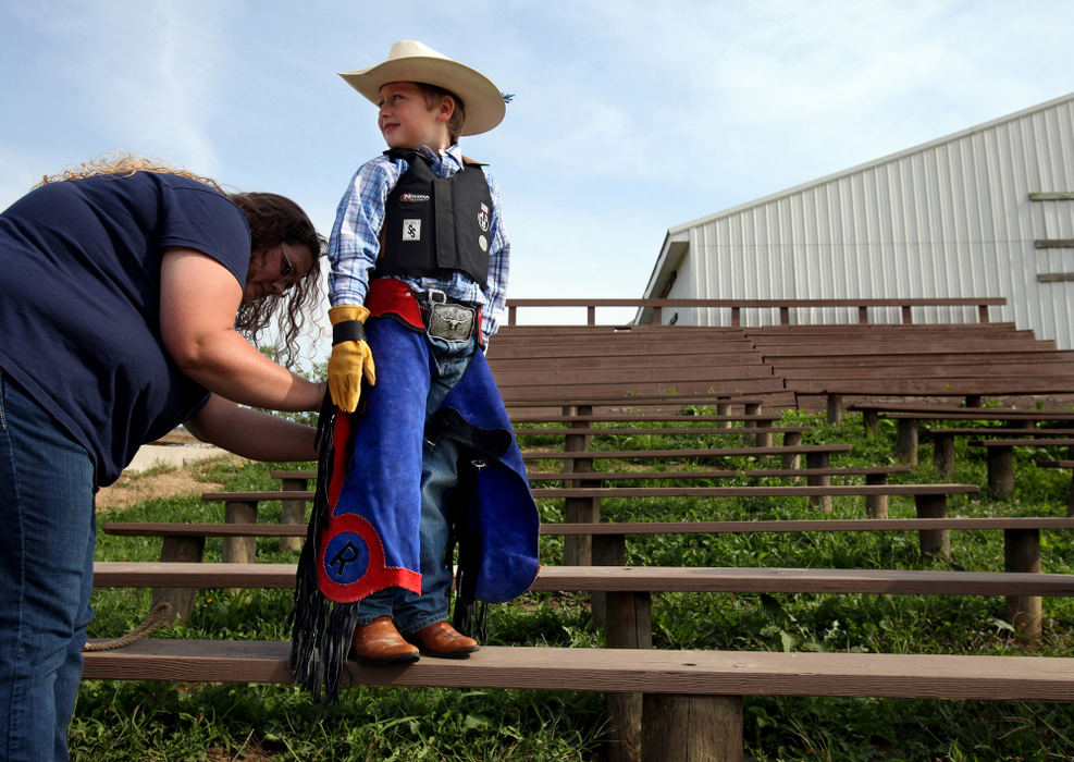 Second Place, Photographer of the Year - Large Market - Lisa DeJong / The Plain Dealer Elizabeth McCullough of Willard, Ohio, left, puts custom-made chaps on her son Riley McCullough, 6, just before he attends Mutton Bustin' School at Buckin' Ohio at Creek Bend Ranch in Burbank, Ohio. The future bull rider has been riding sheep since he was four years old and came to the school to hone his skills. 