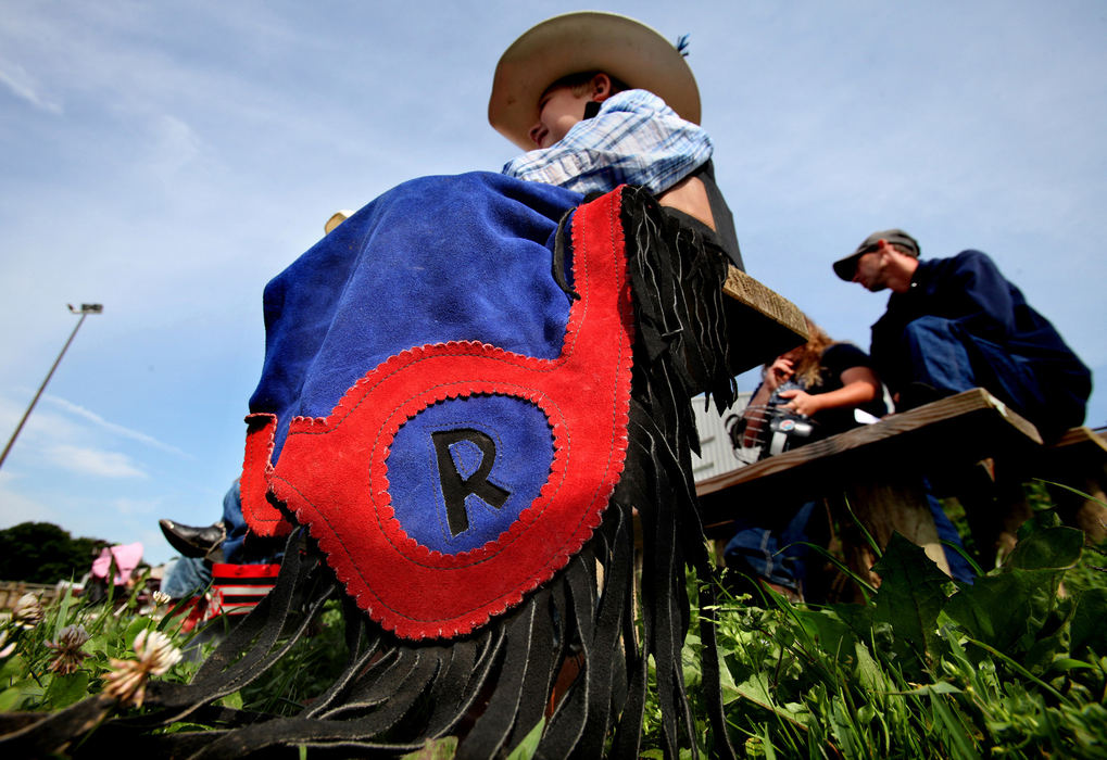 Second Place, Photographer of the Year - Large Market - Lisa DeJong / The Plain DealerRiley McCullough, 6, sporting his very own, custom-made chaps, listens during Mutton Bustin' School at Buckin' Ohio. Riley begged  his mom for the chaps last year. This wee wrangler has been riding sheep since he was four years old. He hopes to hone his skills at the school with the professional bull riders. 