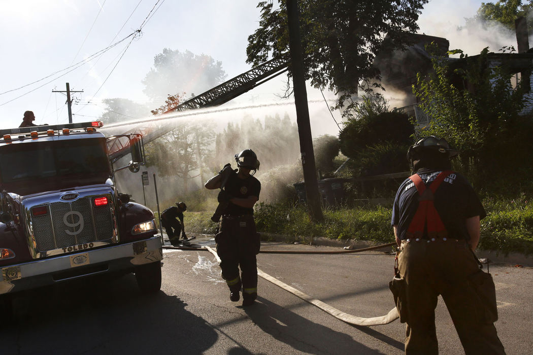 First Place, Photographer of the Year - Large Market - Katie Rausch / The (Toledo) BladeToledo firefighters work to extinguish a blaze that broke out at 758 Hamilton Street in South Toledo Wednesday, July 24, 2013. Neighbors said the house was empty and no injuries were reported. 