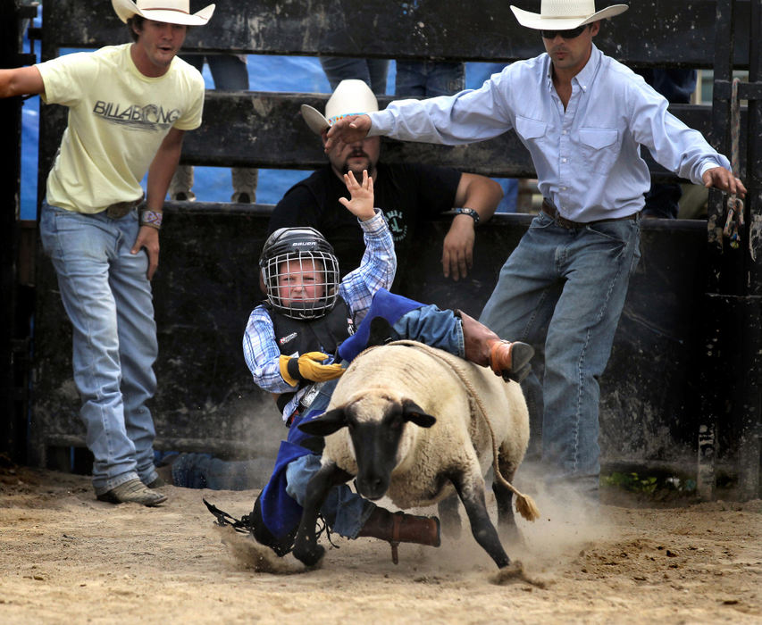 Second Place, Photographer of the Year - Large Market - Lisa DeJong / The Plain DealerRiley McCullough, 6, of Willard, bursts out of the chute on a wooly rocket during his first ride at the Mutton Bustin' School. With a white-knuckled grip of a future bull rider, Riley is learning the art of hanging on for dear life.