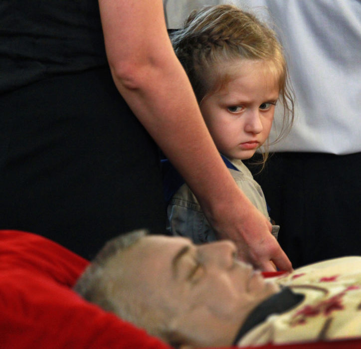 , Photographer of the Year - Large Market - Gus Chan / The Plain DealerKatalina Varro, 7, walks past  the casket of Fr. Sandor Siklodi, during vespers at St. Emeric Catholic Church.  Siklodi died after a sudden illness.  Siklodi was the only priest allowed to return to his former church after eleven churches were ordered by the Vatican to reopen, overturning Bishop Richard Lennon's decree to have them closed.   