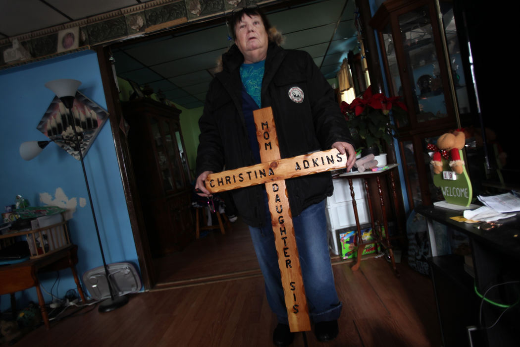 , Photographer of the Year - Large Market - Gus Chan / The Plain DealerMary Adkins holds a wooden cross she'll take to Riverside Cemetery to put on a memorial for her daughter, Christina.  Christina Adkins' body was stuffed in a manhole and her remains went undiscovered for 18 years until her killer, Elias Acevedo, confessed to the crime.