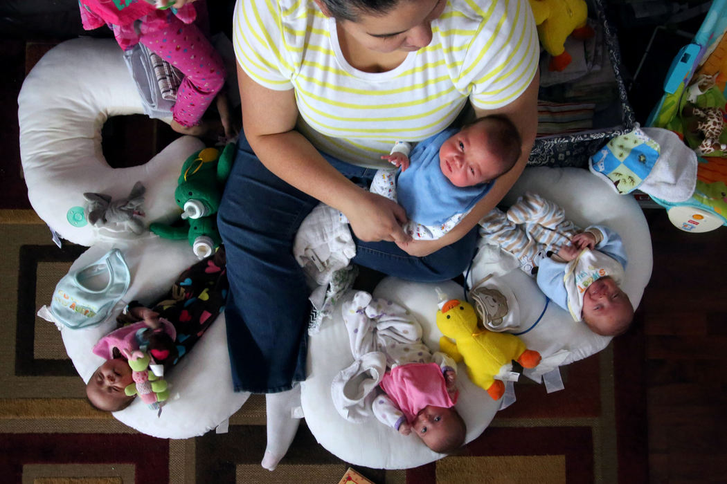 First Place, Photographer of the Year - Large Market - Katie Rausch / The (Toledo) BladeLaura Baldwin holds her son Logan as she feeds the rest of her quadruplets at the home she shares with her husband, Bill, and their three-year-old daughter, Leah, in Swanton. The babies, from left, Reghan, Madalyn and Ryan, are fraternal quadruplets. They were born three months ago at thirty weeks. 