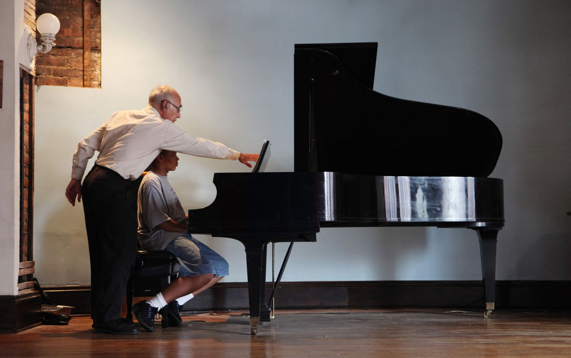 , Photographer of the Year - Large Market - Gus Chan / The Plain DealerPiano instructor Bob Kuebler tries to get Gabriel Walker to read the music during a piano lesson at Broadway School of Music.  Walker, who is autistic, has played piano since he was two.  He takes violin and piano, back to back, at the school on Thursdays.  Walker learned to play by ear but is now learning to read music. 