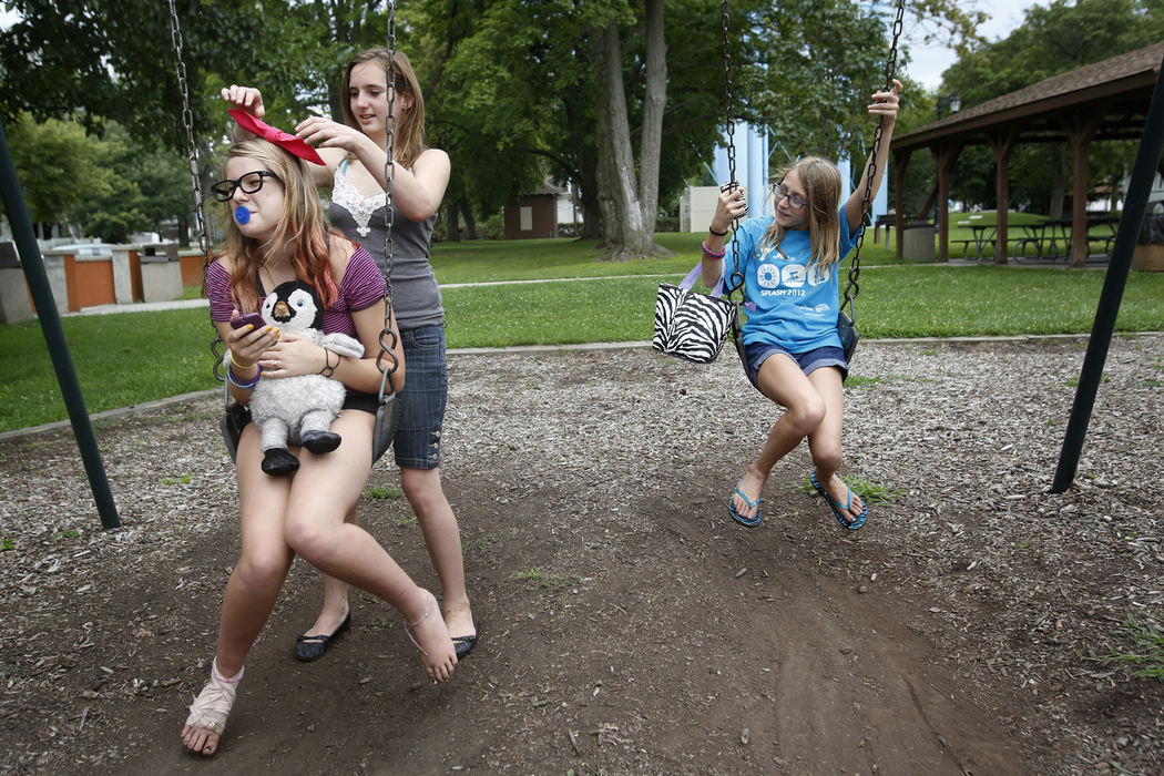 First Place, Photographer of the Year - Large Market - Katie Rausch / The (Toledo) BladeSydney Siddall, 12, left, clutches her penguin Rontu as she has her hair adjusted by Abby Channer, 12, while hanging out with their friend Maddie Prince, 12, all of Sylvania, at Burnham Park on Tuesday, August 6, 2013, in Sylvania. As summer winds down, the park continues to be a popular spot. The girls said they had come to hang out in the park because it was close to home. 