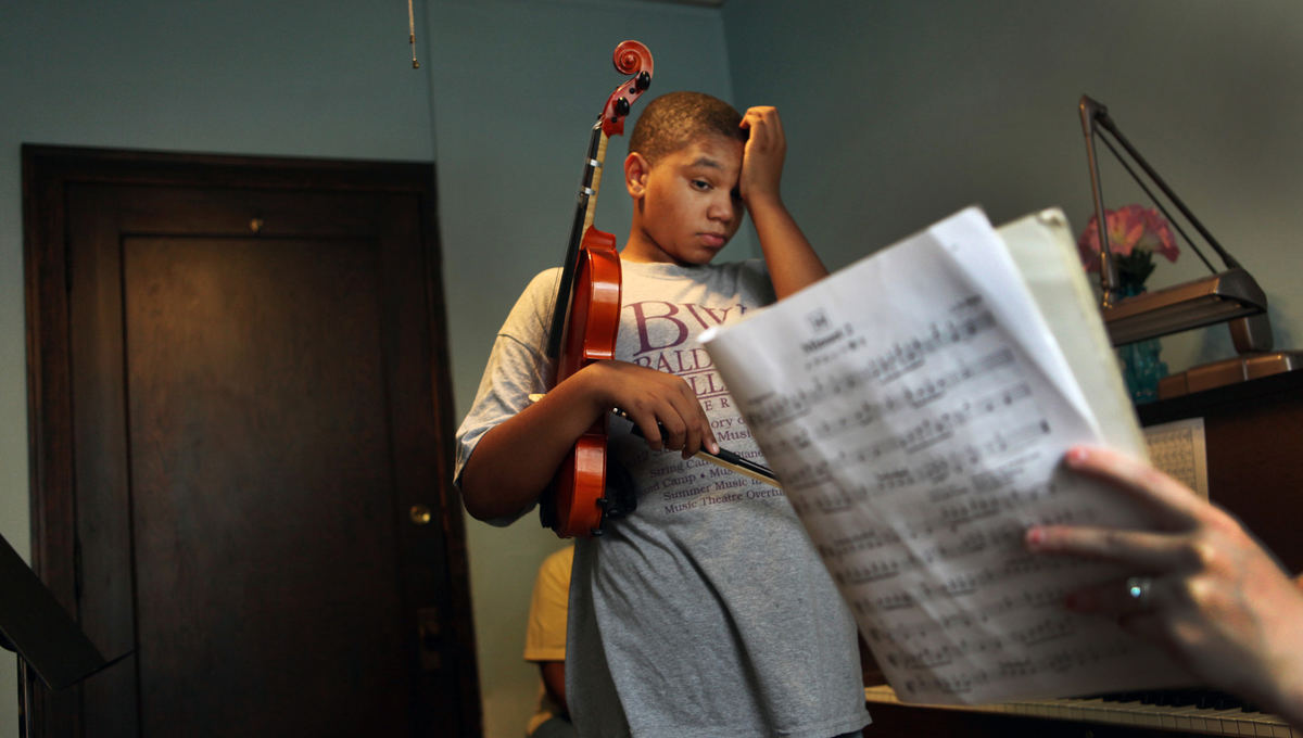 , Photographer of the Year - Large Market - Gus Chan / The Plain DealerGabriel Walker listens as his teacher, Laura Frazelle, plays a piece of music at Broadway School of Music.  Walker, who is autistic, has played piano since he was two.  He takes violin and piano, back to back, at the school on Thursdays.  