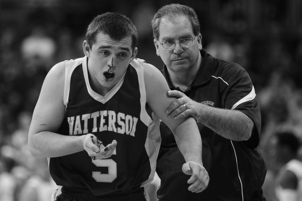 First Place, Photographer of the Year - Small Market - Joshua A. Bickel / ThisWeek Community NewsHead coach Vince Lombardo, right, helps Bishop Watterson's Cody Calhoun, left, heads to the bench after being hit in the face during Watterson's state final against Akron St. Vincent-St. Mary Mar. 23, 2013 at Value City Arena in Columbus, Ohio. Calhoun left the game briefly in the fourth quarter after getting hit, returning about a minute later to score five of his 14 points in the final five minutes of the game.