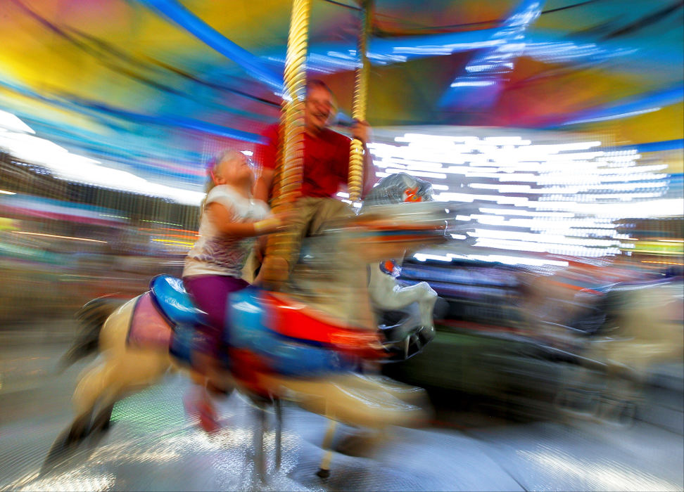 Second Place, Photographer of the Year - Small Market - Barbara J. Perenic / Springfield News-SunJaelyn Wooten, 3, gazes at the lights above while riding the merry-go-round with her father James Wooten at the Clark County Fair on Tuesday night.
