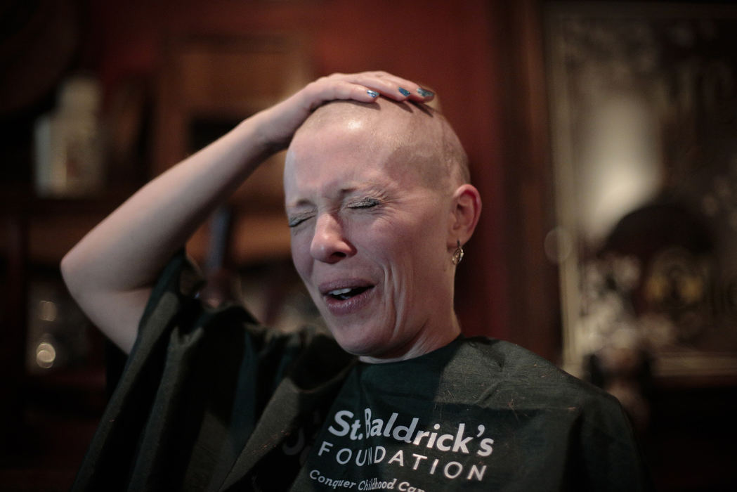 First Place, Photographer of the Year - Small Market - Joshua A. Bickel / ThisWeek Community NewsGahanna resident Sarah Gee reacts as she feels her head for the first time after shaving it as part of a fundraising campaign for the St. Baldrick's Foundation, a group that supports childhood cancer research, Nov. 24, 2013 at Easton Town Center's Fado Irish Pub and Grill in Columbus, Ohio. Gee  and several others raised more than $5,500 for the charity. Gee also donated her hair for use in wigs for cancer patients.