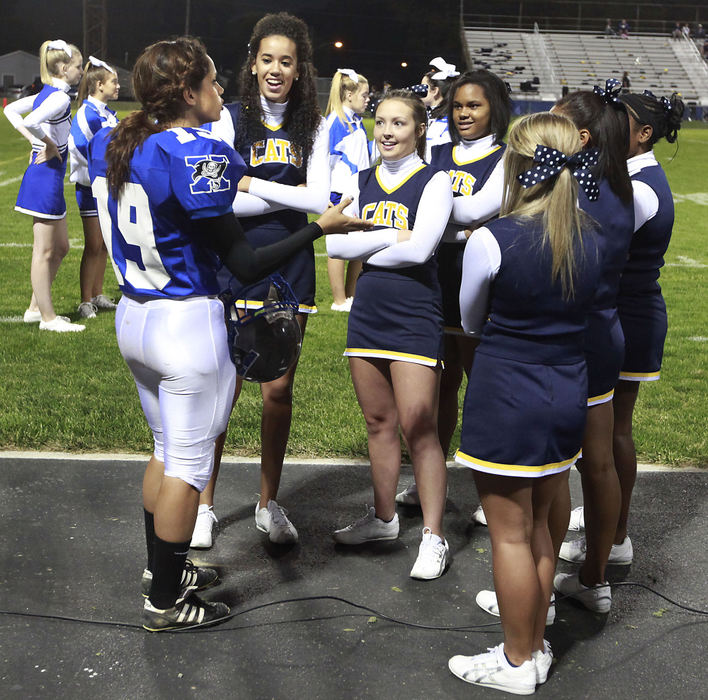 Third Place, Photographer of the year - Small Market - Bill Lackey / Springfield News-SunXenia High School football player Alexis Qumsieh talks with Springfield High School cheerleaders before the start of the second half of Friday nights match-up. Alexis is a kicker on the football team.