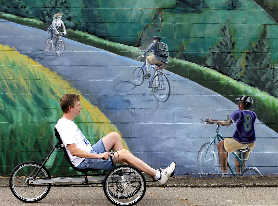 Third Place, Photographer of the year - Small Market - Bill Lackey / Springfield News-SunJerry Caudill rides a recumbant bicycle past the mural on the side wall of the Bicycle Stop in Springfield Friday. Caudill was taking the bike for a test ride around the business before purchasing it. 