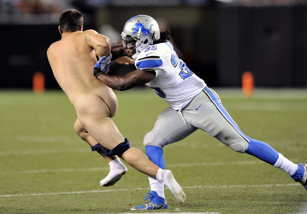 Award of Excellence, Sports Feature - David Richard / FreelanceDetroit Lions running back Joique Bell pushes a nude fan who ran on to the playing field during a preseason NFL football game between the Lions and the Cleveland Browns.