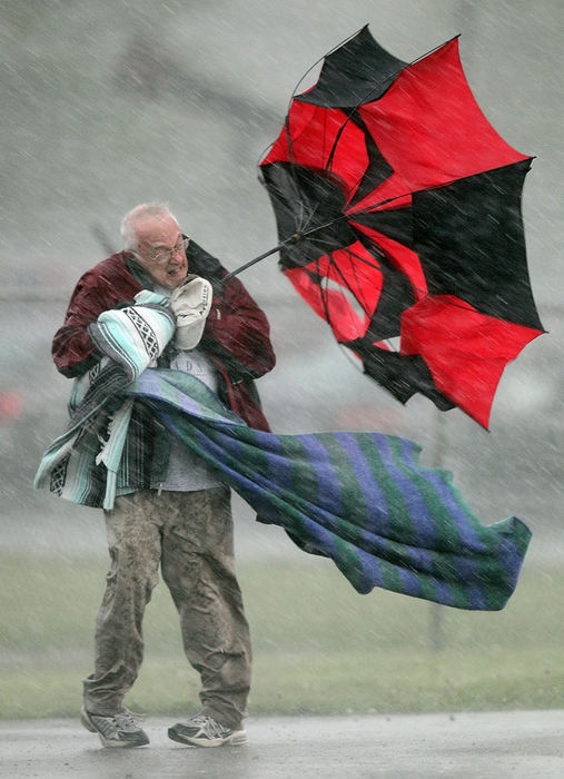 Award of Excellence, Sports Feature  - Phil Masturzo / Akron Beacon JournalTallmadge track fan Duane Munk braves the elements heading back to his vehicle during a rain delay at the Rock 'em Relays track meet at Lake High School. 