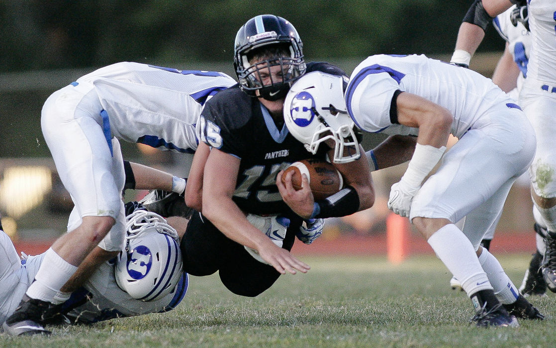 First Place, Ron Kuntz Sports Photographer of the Year - Joshua A. Bickel / ThisWeek Community NewsHilliard Darby quarterback Nate Green (15) falls to the ground as he's tackled by Hilliard Davidson defensive backs Joe Bernard, left, and Nick Stull, right, during Darby's football game against Hilliard Davidson Sept. 6, 2013 at Hilliard Darby High School in Hilliard, Ohio.