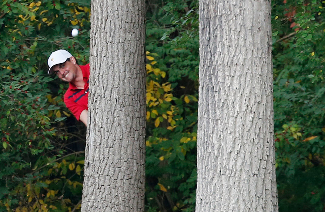 Second Place, Ron Kuntz Sports Photographer of the Year - Adam Cairns / The Columbus DispatchAfter Phil Mickelson hit the ball into the rough, Keegan Bradley of the United States Team is forced to hit an awkward shot from behind a pair of trees on the 1st fairway during the Presidents Cup at Muirfield Village Golf Club on Oct. 5, 2013. Mickelson and Bradley were paired up for the alternate-shot round.