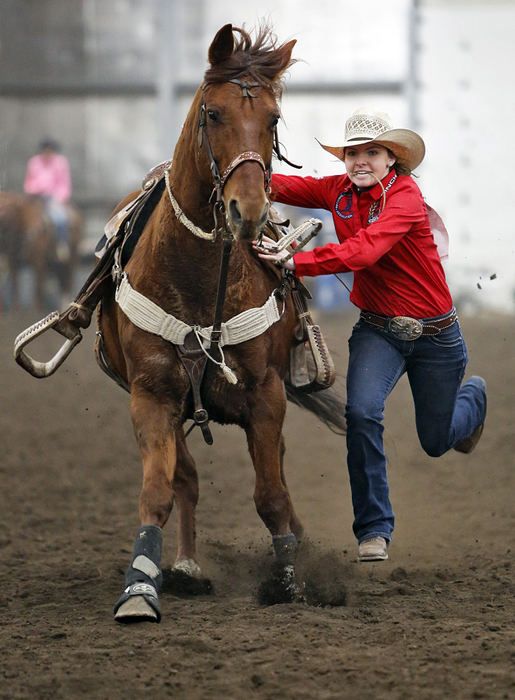 Award of Excellence, Ron Kuntz Sports Photographer of the Year - Chris Russell / The Columbus Dispatch Lost amongst all the high school basketball, baseball and football tournaments is the Ohio High School State Rodeo Tournament.  The sport is huge in the American west, but obscure in Ohio.  However, there is a small group of youngsters who are committed to the sport.Competing in a late winter indoor rodeo,  Josie Hume jumps from her horse named Speck during a goat tying event. She was competing in preparation for the upcoming high school rodeo season.
