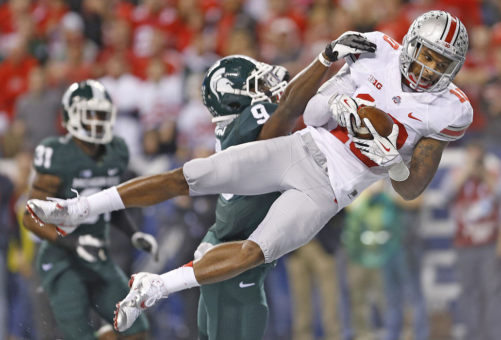 Award of Excellence, Ron Kuntz Sports Photographer of the Year - Chris Russell / The Columbus DispatchOhio State Buckeyes wide receiver Philly Brown (10) keeps his eyes on the end zone as he dives for TD reception in the second quarter over defense by Michigan State Spartans safety Isaiah Lewis (9) at Lucas Oil Stadium in Indianapolis, Ohio.