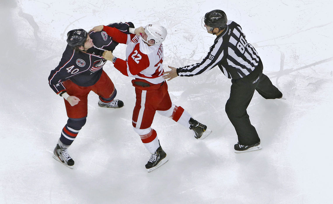 Award of Excellence, Ron Kuntz Sports Photographer of the Year - Chris Russell / The Columbus Dispatch Columbus Blue Jackets right wing Jared Boll (40) and Detroit Red Wings right wing Jordin Tootoo (22) get into a fight seconds into the home opener at Nationwide Arena on January 21, 2013.  