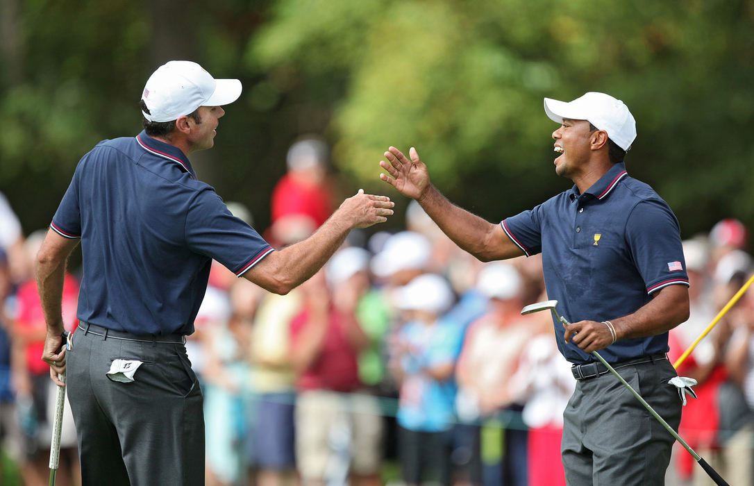 Award of Excellence, Ron Kuntz Sports Photographer of the Year - Chris Russell / The Columbus DispatchMatt Kuchar of the United States Team high fives teammate Tiger Woods  after Kuchar earned the team a point one the first hole during the first round of the Presidents Cup at Muirfield Village Golf Club in Dublin, Ohio on October 3, 2013.  