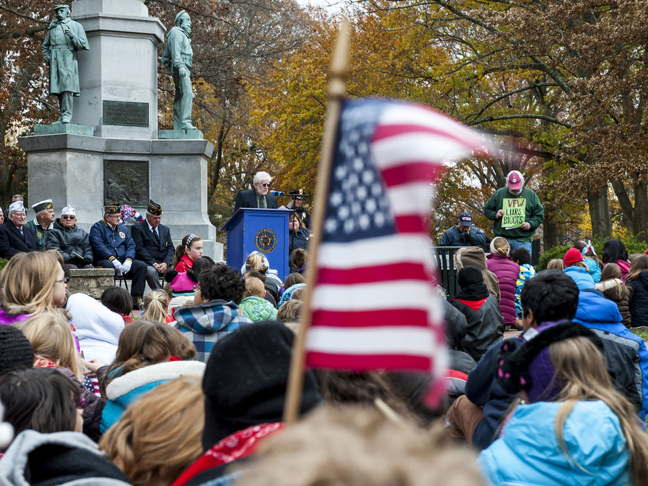 Third Place, Student Photographer of the Year - Logan Riely / Ohio UniversityOhio University's athletic announcer and military veteran Lou Horvath (left) gives a speech in front of grade school students and other branches of the military while Athens, Ohio native Eliot Kalman (right) stands alone to protest the Veterans of Foreign Wars (VFW) organization during a Veteran's Day memorial service at College Green, on Nov. 11, 2013, in Athens, Ohio. 