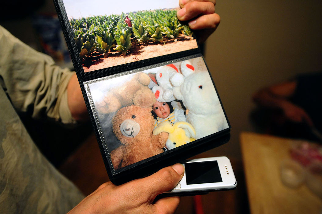 Third Place, Student Photographer of the Year - Logan Riely / Ohio UniversityGabriel Moreno thumbs through a small photo album of his 3-year-old daughter, Angel, who lives with his wife in Michoacán, Mexico. Gabriel says that he is working hard so that can provide a better life for his daughter.  