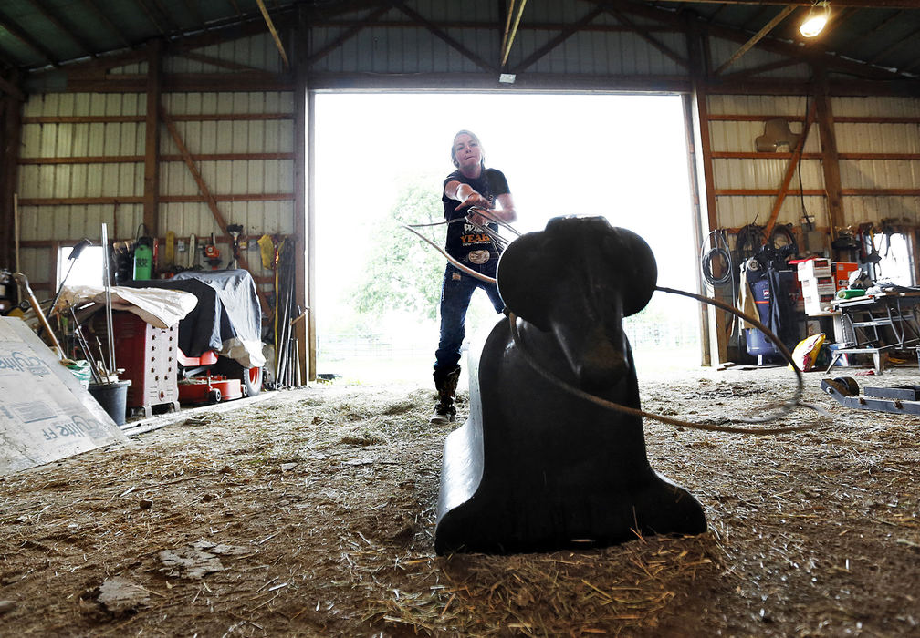 Second Place, Sports Picture Story - Chris Russell / The Columbus DispatchDuring the heat of a summer day , Josie sought the shade of the barn to practice her rope throw on a plastic calf .