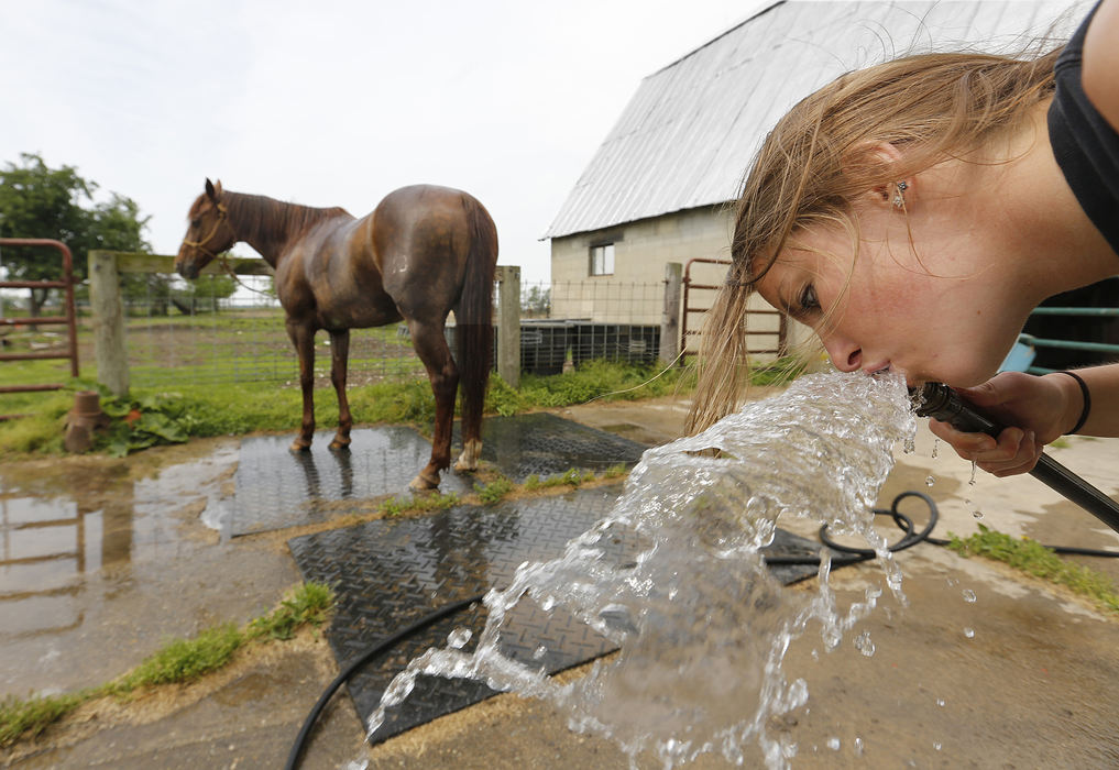 Second Place, Sports Picture Story - Chris Russell / The Columbus DispatchAfter doing some barrel racing practice  Josie takes a drink of water from the hose while Speck waits patiently after a session at their house on May 8, 2013.  
