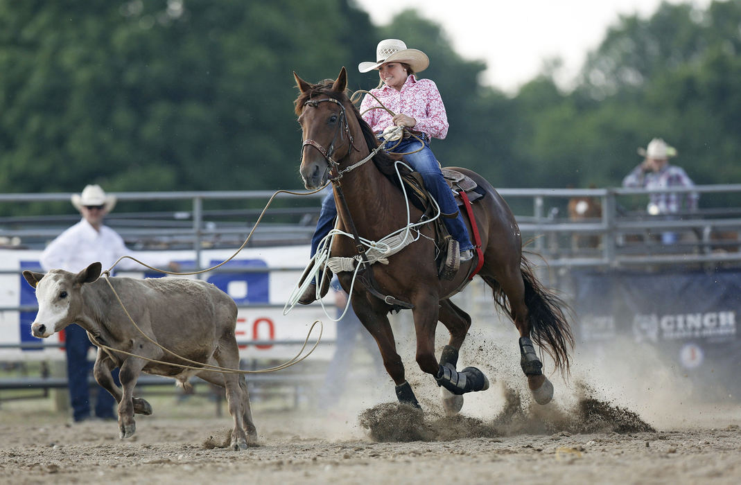 Second Place, Sports Picture Story - Chris Russell / The Columbus Dispatch Josie successfully ropes her calf in the opening event of the Ohio High School Rodeo Championship in Urbana.