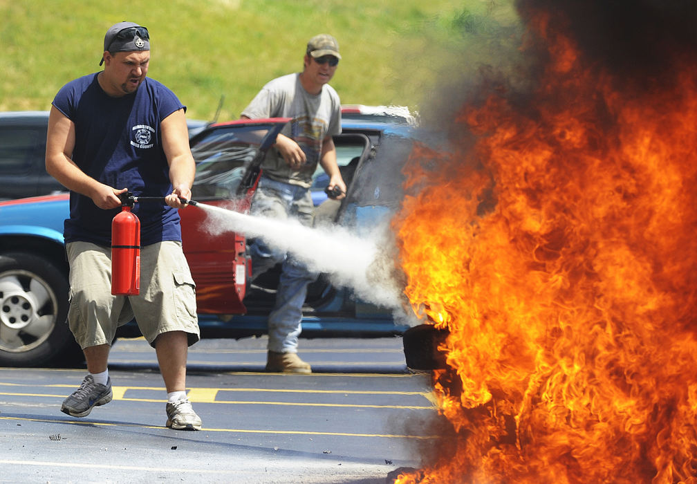 Third Place, Spot News - Small Market - Brent Lewis / Chillicothe GazetteFirefighter Michael Hawkins tries to calm the fire from a car that caught fire in the parking lot of Corner Market. "It just got hot and died," said Corinda Krans, driver of the car. "It wouldn't restart and smoke just kept getting higher." Krans told her two children to get out of the car and moments later the front of the car was engulfed in flames. "We barely got out," said Krans.